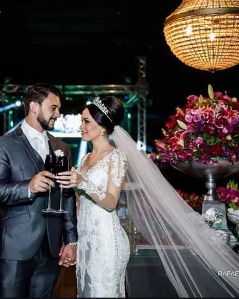 Noivos brindando em casamento com luz de palco ao fundo
